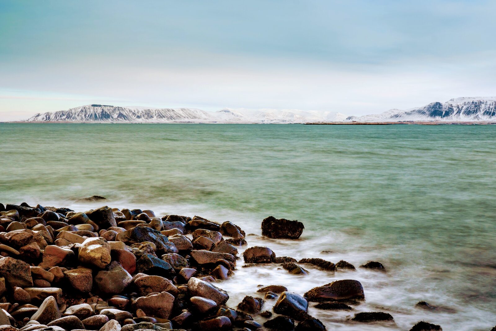 Rocky Reykjavík coastline with Mount Esja in the distance