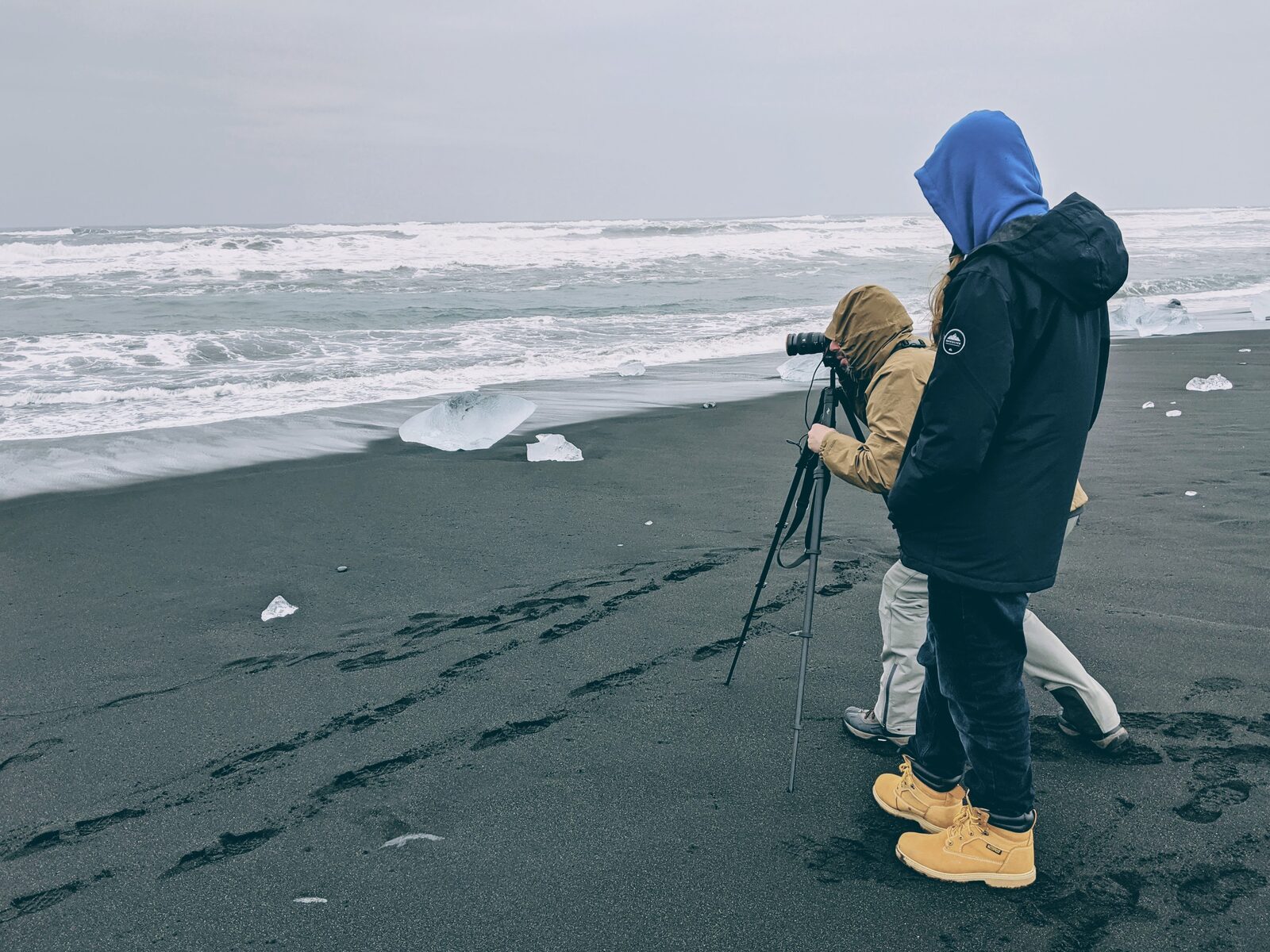 Photographers working on Diamond Beach with icebergs behind